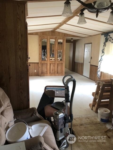 interior space featuring lofted ceiling and wood walls