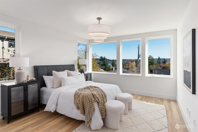 bedroom with light wood-type flooring and multiple windows