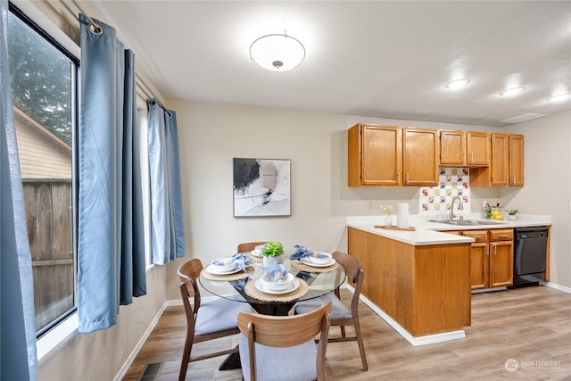 kitchen featuring black dishwasher, kitchen peninsula, plenty of natural light, and sink