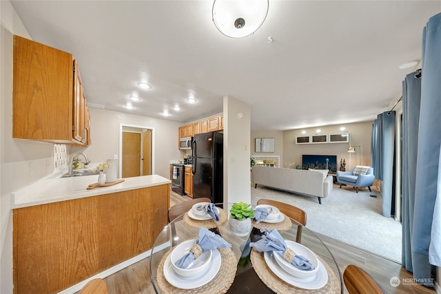 dining room featuring sink and light colored carpet