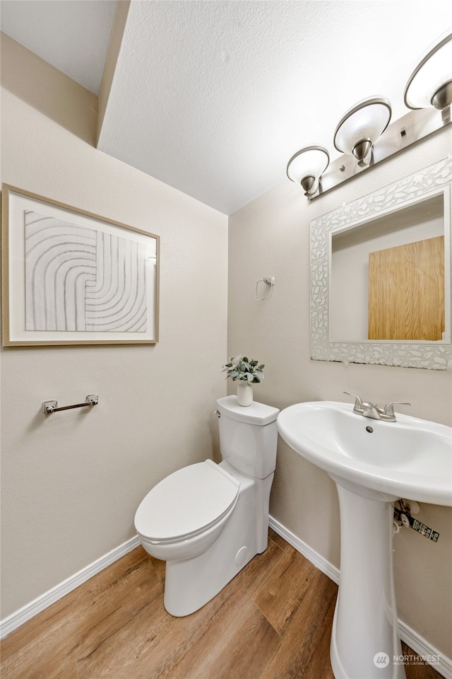 bathroom with wood-type flooring, sink, and toilet