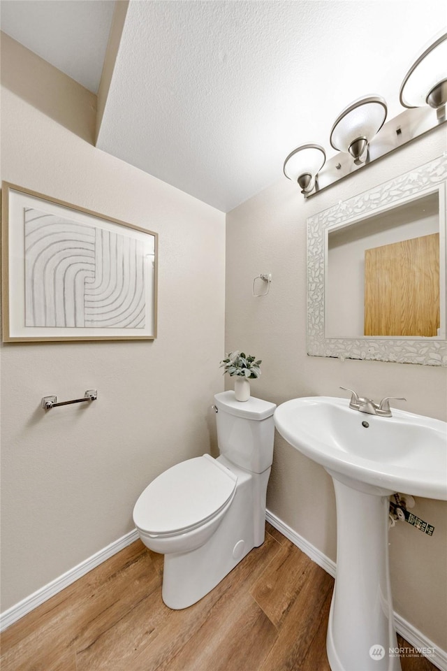 1302 3rd St SE Unit 1, Auburn, WA 98002 - bathroom featuring wood finished floors, toilet, baseboards, and a sink