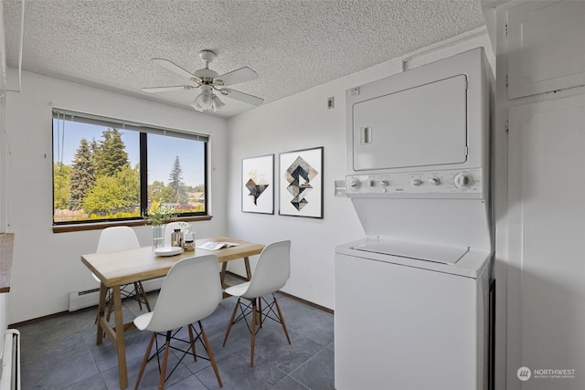 dining room featuring a textured ceiling, dark tile patterned flooring, ceiling fan, and stacked washer and clothes dryer