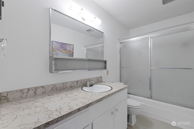 full bathroom with toilet, vanity, a textured ceiling, and enclosed tub / shower combo