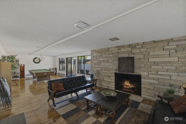 living room with a fireplace, hardwood / wood-style flooring, a textured ceiling, and billiards