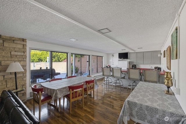 dining space featuring dark hardwood / wood-style flooring and a textured ceiling