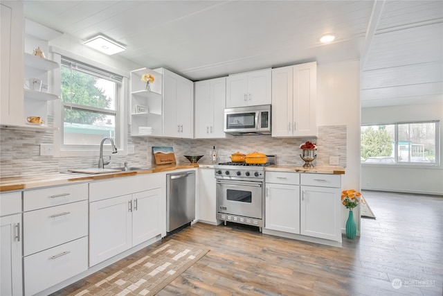 kitchen with white cabinetry, a wealth of natural light, appliances with stainless steel finishes, and light hardwood / wood-style floors