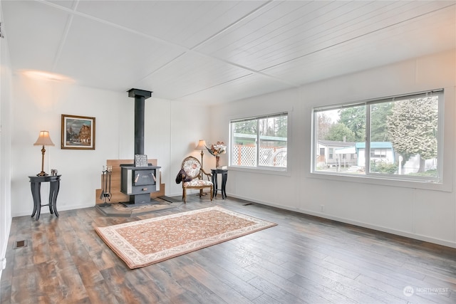 unfurnished room with hardwood / wood-style floors and a wood stove