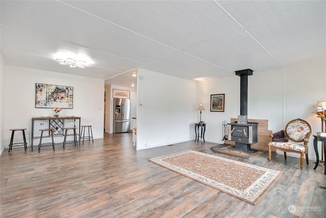 sitting room with a wood stove and hardwood / wood-style flooring