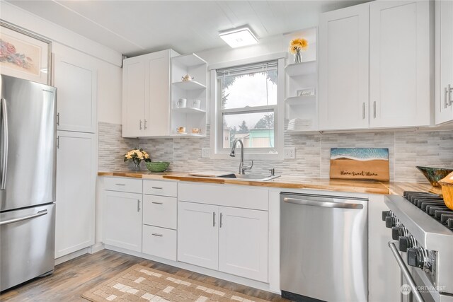 kitchen featuring white cabinetry, appliances with stainless steel finishes, light hardwood / wood-style flooring, and wood counters