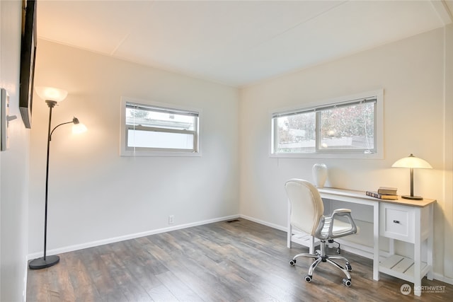 unfurnished office with dark wood-type flooring and a wealth of natural light