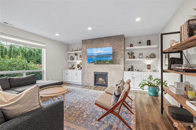 living room with a tiled fireplace and dark hardwood / wood-style floors