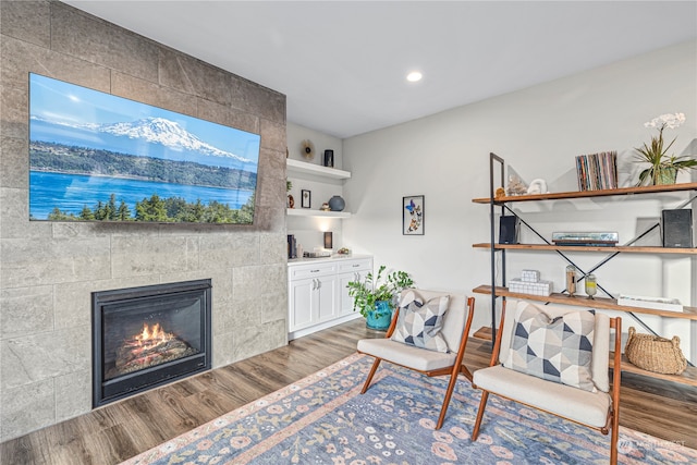 living area featuring hardwood / wood-style floors and a tile fireplace