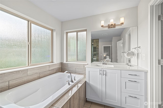 bathroom featuring vanity, a healthy amount of sunlight, tile patterned floors, and separate shower and tub