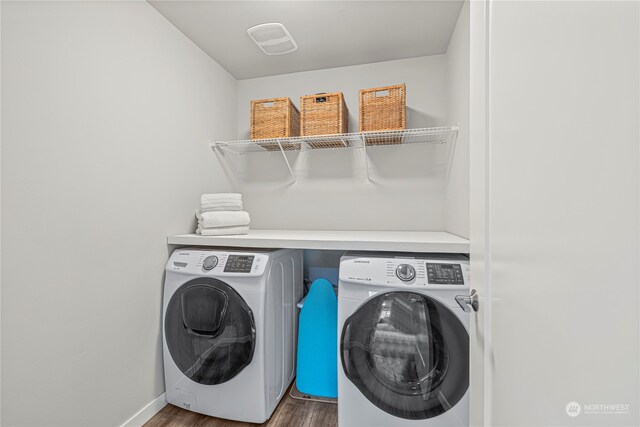 washroom with dark hardwood / wood-style flooring and washer and dryer