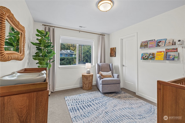 bedroom featuring a nursery area and light carpet