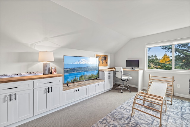 carpeted office featuring vaulted ceiling