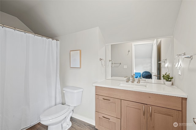 bathroom with hardwood / wood-style floors, vanity, toilet, and vaulted ceiling