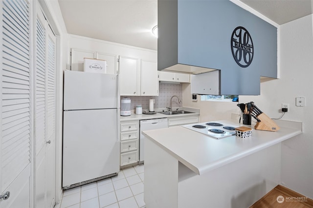 kitchen featuring sink, kitchen peninsula, tasteful backsplash, white appliances, and white cabinets