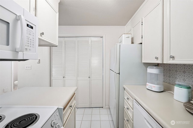 kitchen featuring white cabinetry, white appliances, and light tile patterned floors