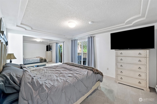 carpeted bedroom featuring ornamental molding, a textured ceiling, a tray ceiling, and access to outside