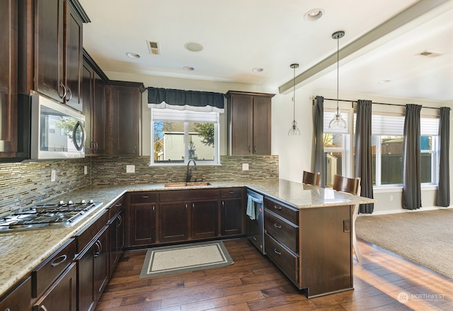 kitchen featuring hanging light fixtures, a breakfast bar area, tasteful backsplash, dark hardwood / wood-style floors, and appliances with stainless steel finishes