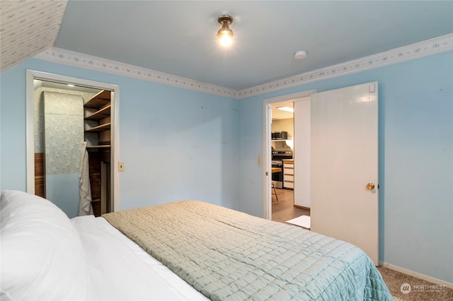 carpeted bedroom with a closet, a spacious closet, and vaulted ceiling