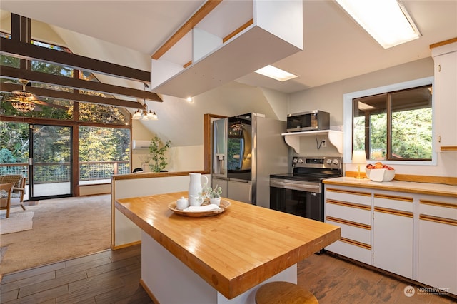 kitchen featuring stainless steel appliances, dark hardwood / wood-style flooring, white cabinets, ceiling fan, and a center island