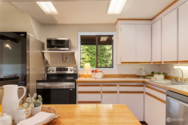 kitchen with stainless steel appliances, white cabinetry, and sink