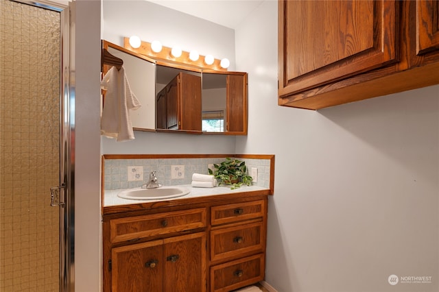 bathroom with decorative backsplash, vanity, and a shower with shower door