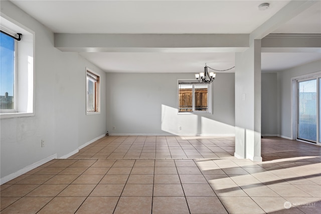 unfurnished living room with a barn door, a chandelier, and light tile patterned floors