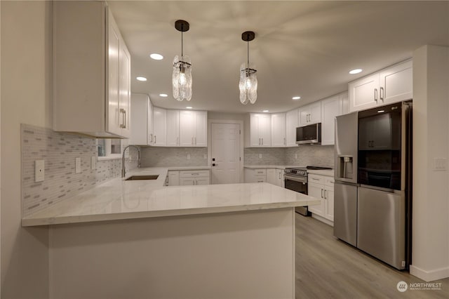34716 169th Ave SE, Auburn, WA 98092 - kitchen with appliances with stainless steel finishes, a peninsula, light wood-style flooring, light stone counters, and tasteful backsplash
