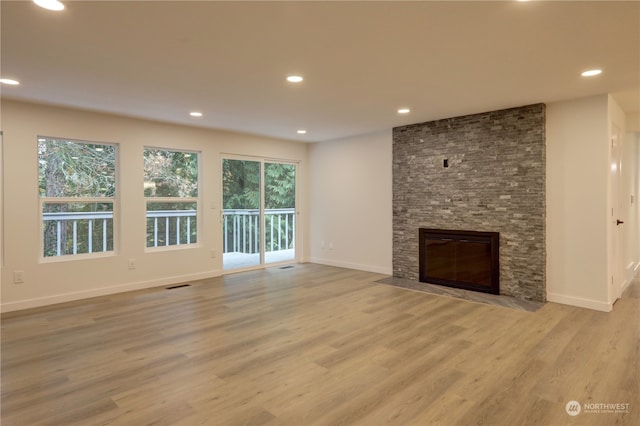 unfurnished living room with a fireplace and light hardwood / wood-style flooring