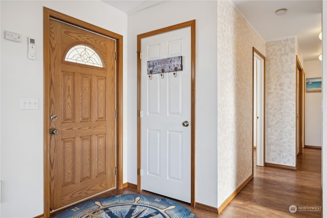foyer with baseboards and wood finished floors