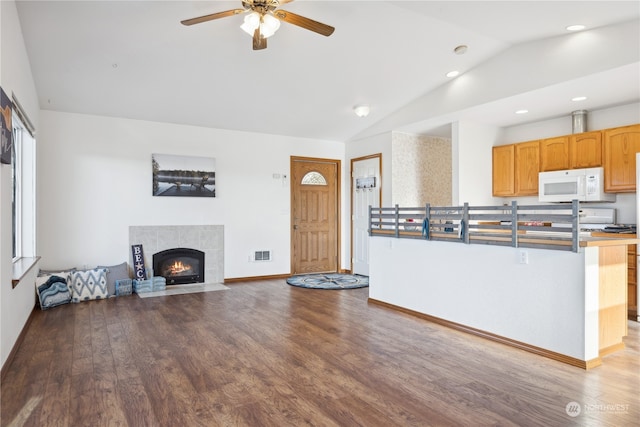 living room with wood finished floors, visible vents, baseboards, a fireplace, and vaulted ceiling