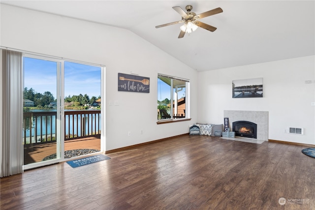 living room featuring vaulted ceiling, visible vents, a fireplace, and wood finished floors