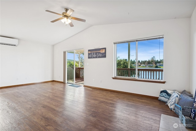 spare room with hardwood / wood-style floors, a wall unit AC, baseboards, ceiling fan, and vaulted ceiling
