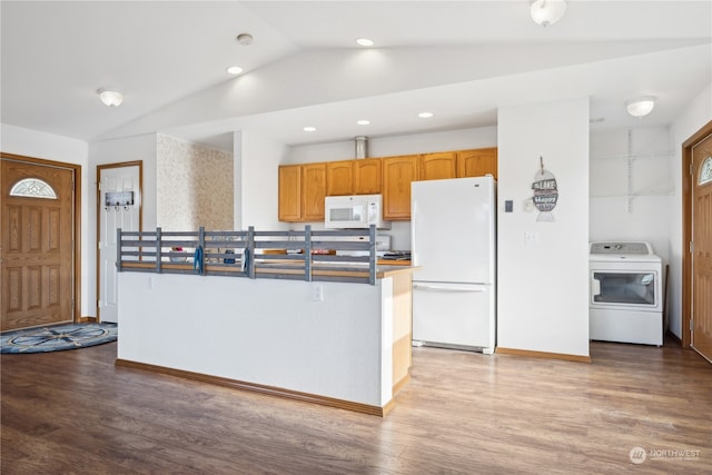 kitchen featuring vaulted ceiling, white appliances, washer / clothes dryer, and wood finished floors
