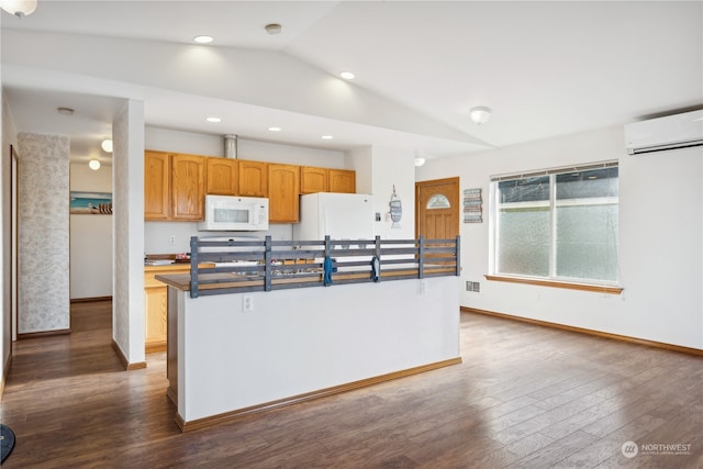 kitchen with white appliances, an island with sink, an AC wall unit, dark wood-type flooring, and vaulted ceiling
