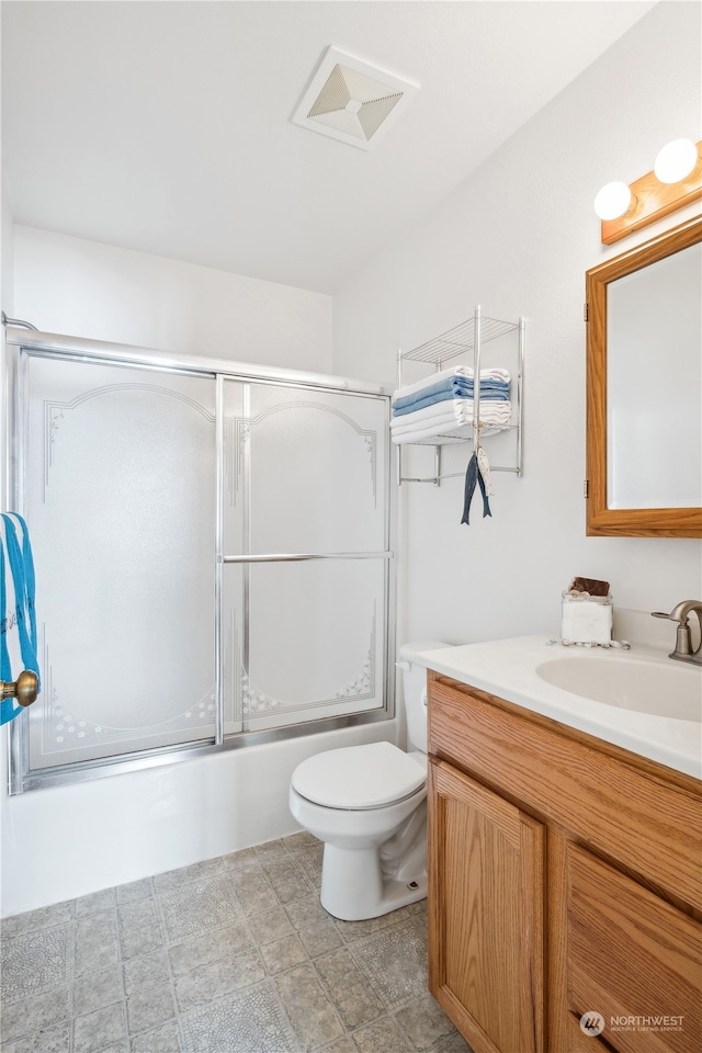 bathroom with combined bath / shower with glass door, visible vents, toilet, and vanity