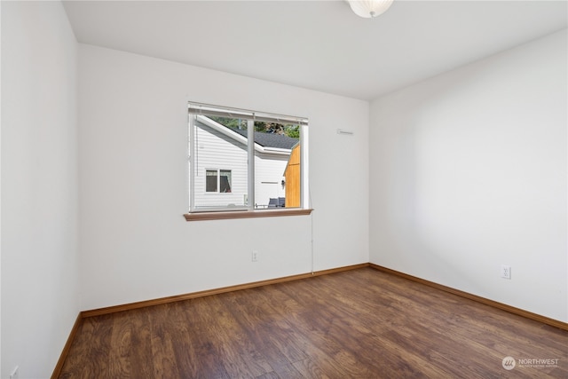 empty room with baseboards and wood finished floors