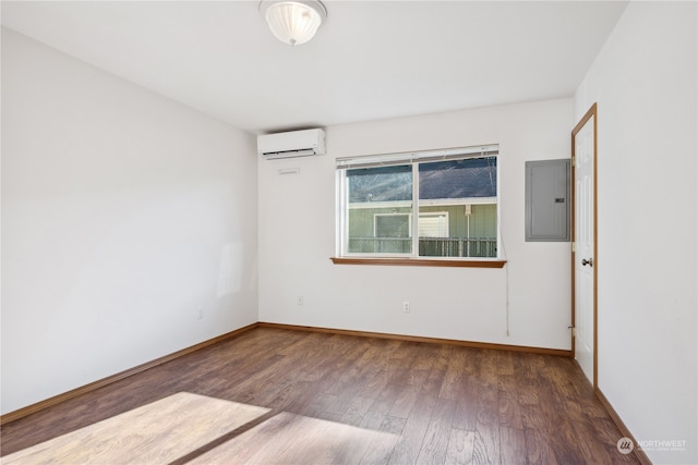 spare room with electric panel, wood finished floors, baseboards, and a wall mounted air conditioner