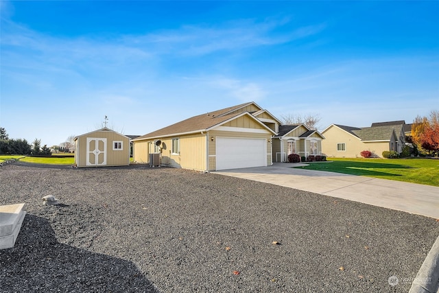 single story home featuring a front lawn, central air condition unit, a garage, and a storage shed