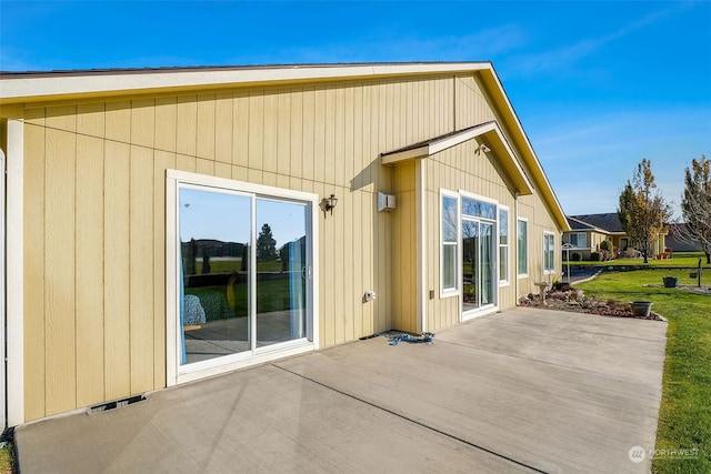 rear view of property featuring a lawn and a patio area