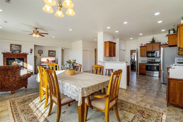 dining area featuring ceiling fan with notable chandelier