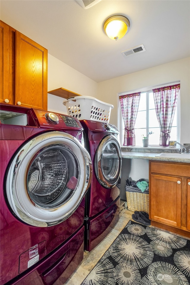 laundry area featuring sink, cabinets, and independent washer and dryer