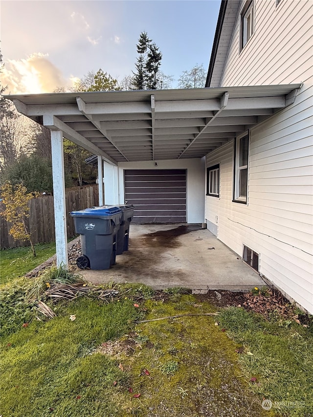 parking at dusk featuring a yard and a carport