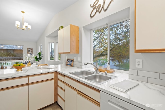 kitchen with decorative light fixtures, sink, vaulted ceiling, white cabinets, and a chandelier