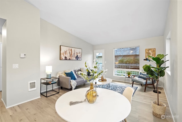 living room featuring light hardwood / wood-style floors and vaulted ceiling