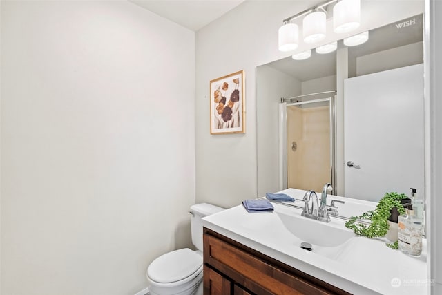 bathroom with vanity, toilet, and a shower with door